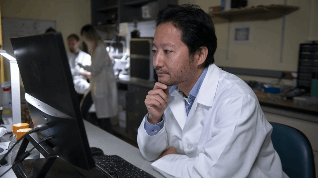 Pensive professor in white coat working in laboratory. 