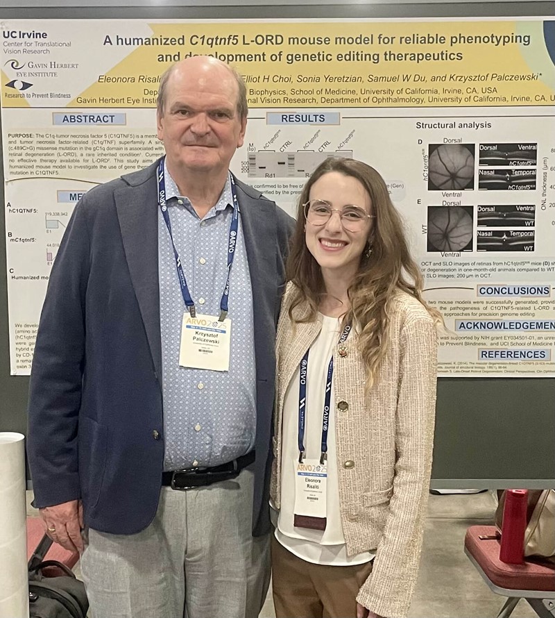 Professor and student researcher stand in front of a poster presentation. 