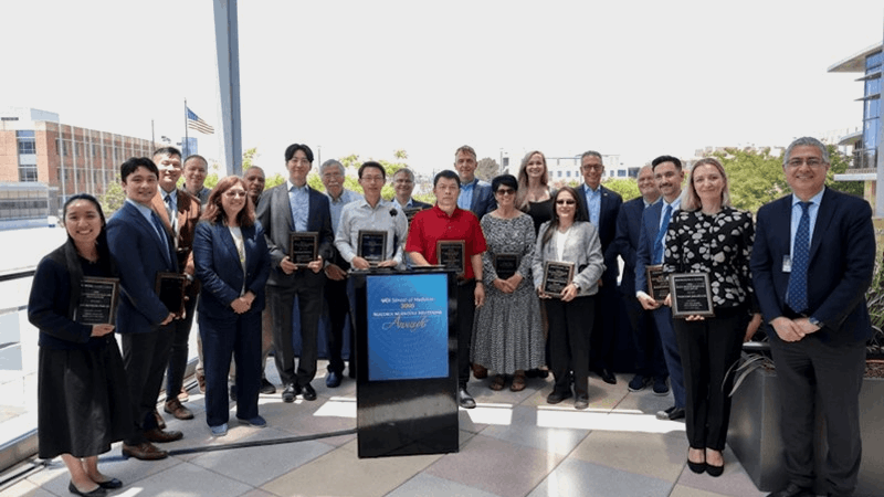 Large group of faculty posing together at an awards luncheon.
